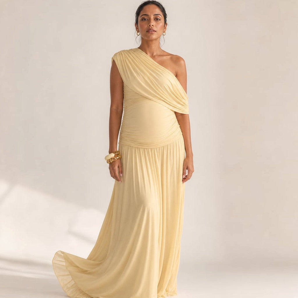 Rowan one-shoulder asymmetric maternity maxi dress in apricot, full-length front view showing gathered waist and floor-length skirt