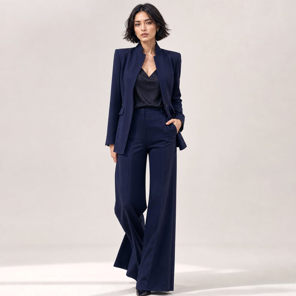 Vael two-piece suit in navy blue — stand collar blazer with single-button closure and wide-leg tailored trousers, front view on model