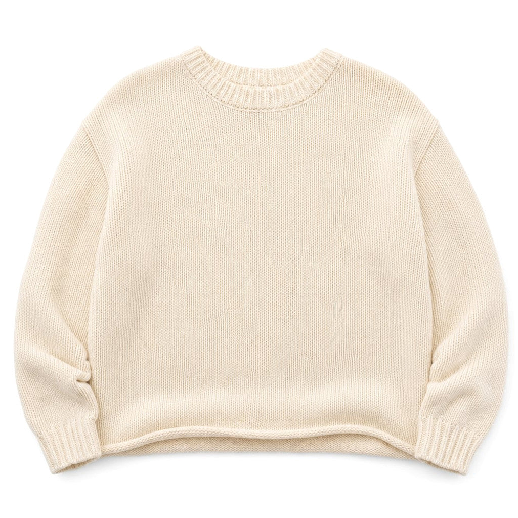 Model wearing Nikova cream cotton knit jumper with straight-leg trousers
