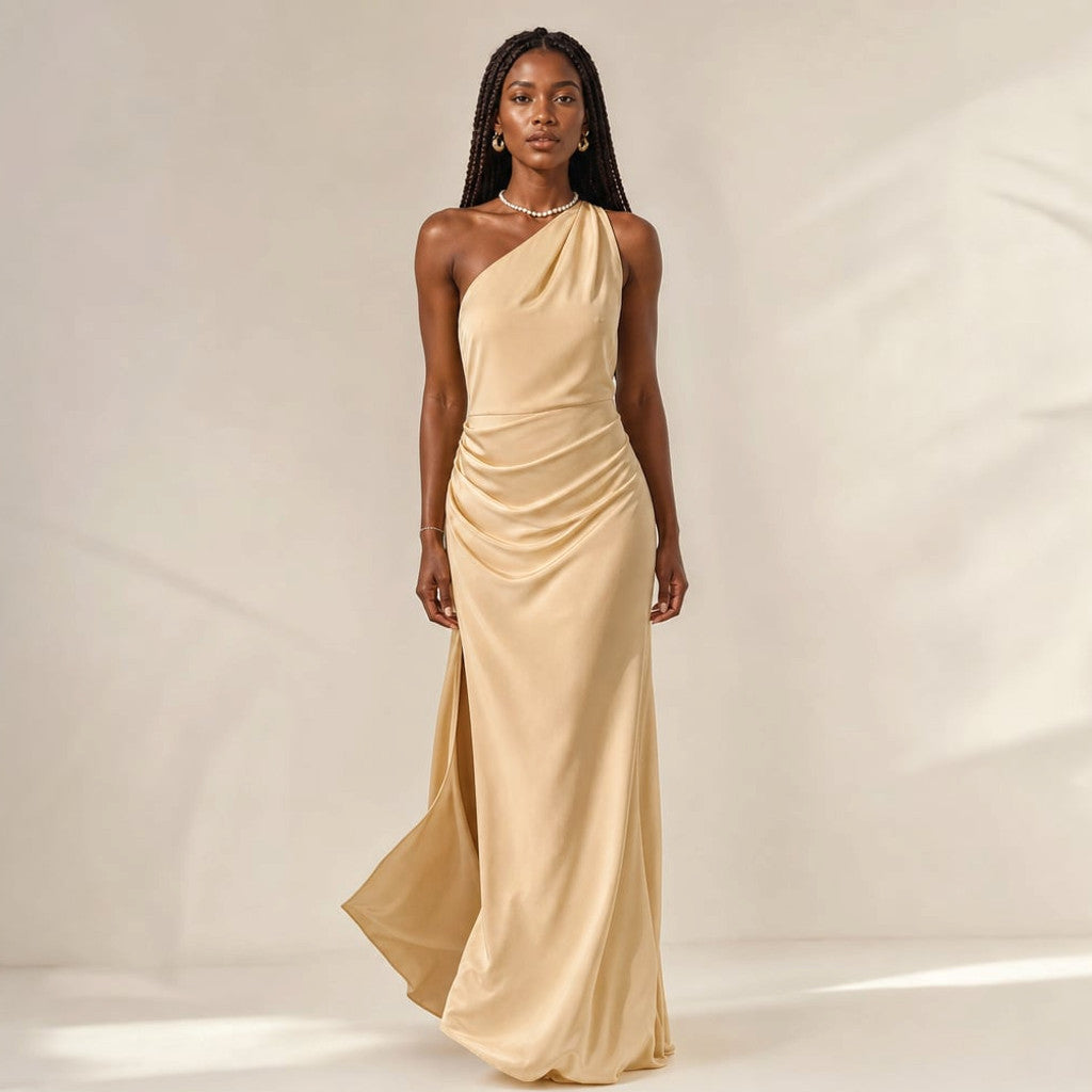 Asymmetrical maxi dress in light brown with a floor-length slit hem, fitted bodice, and smooth drape — front view on white background.