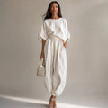 Model wearing Sael white linen co-ord set with wide-leg trousers and relaxed draped blouse