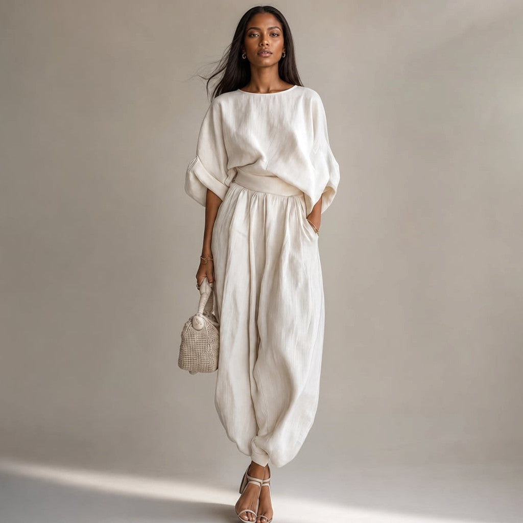 Model wearing Sael white linen co-ord set with wide-leg trousers and relaxed draped blouse