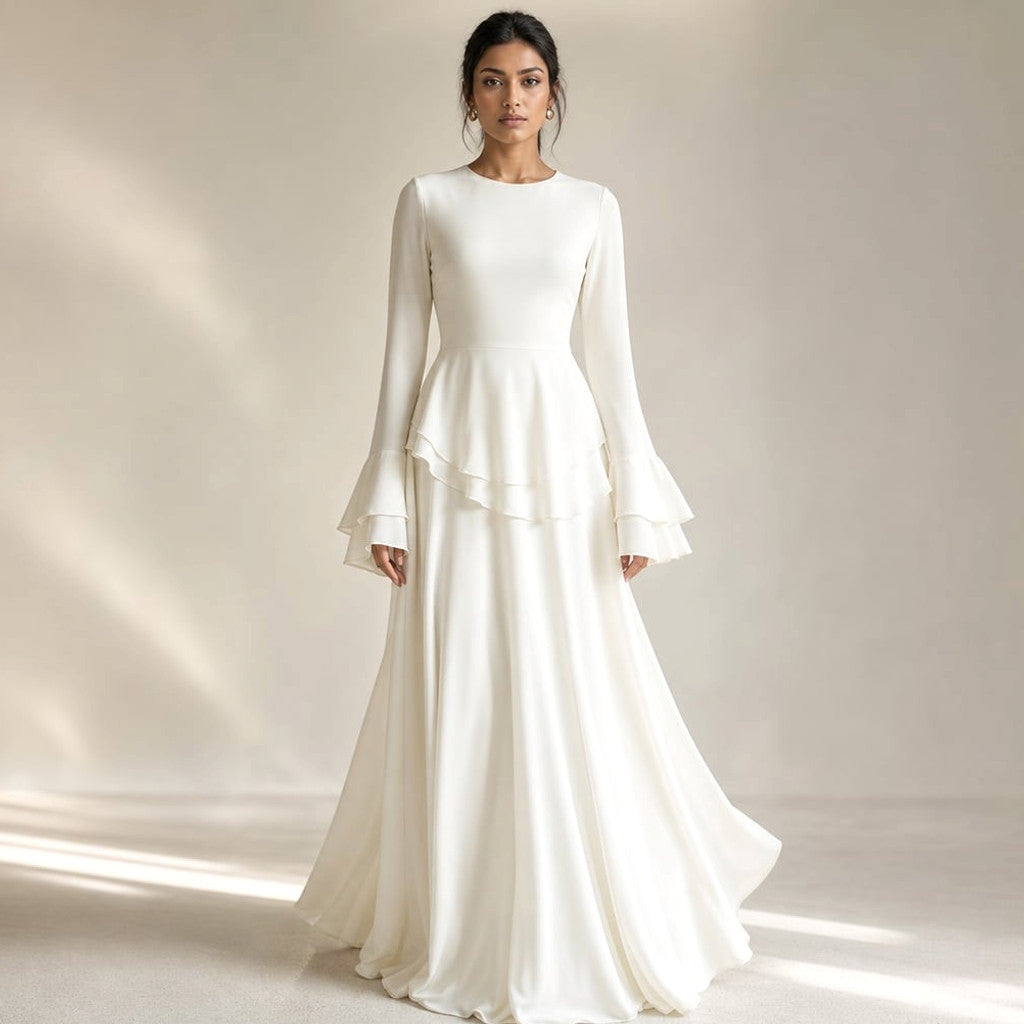 White flared maxi dress with tiered ruffle bodice and long flared sleeves, floor-length silhouette on a light background