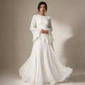Model wearing white ruffle-sleeve maxi dress with fitted bodice and full-length flared skirt