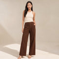 Model wearing Kady chocolate denim wide-leg trousers with high waistband, styled with a tucked top