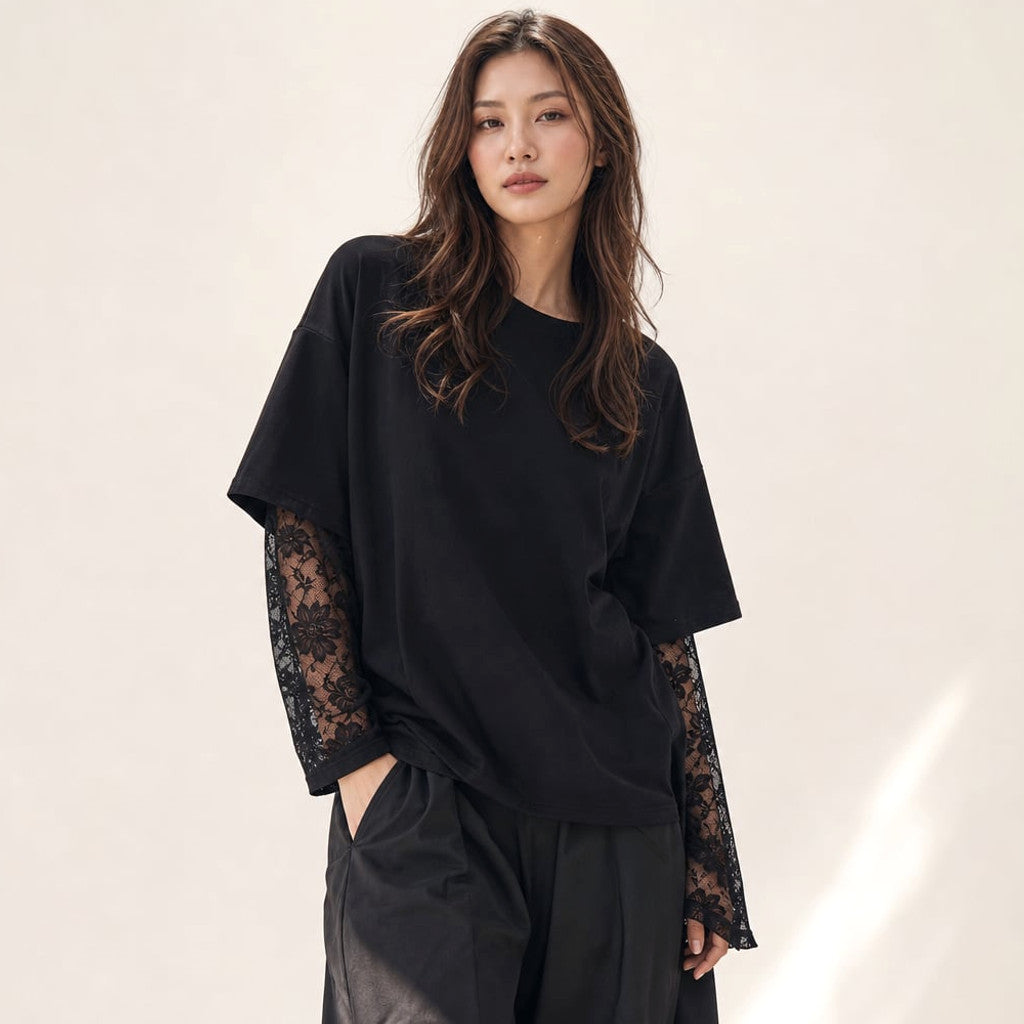 Model wearing Francesca black cotton-blend knit top with lace forearm sleeves, styled with tailored trousers