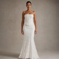 Model wearing white lace strapless corset mermaid gown, full-length silhouette showing thigh-to-floor flare