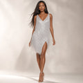 Model wearing silver all-over sequin mini dress with stacked fringe tiers at skirt and deep V-neckline