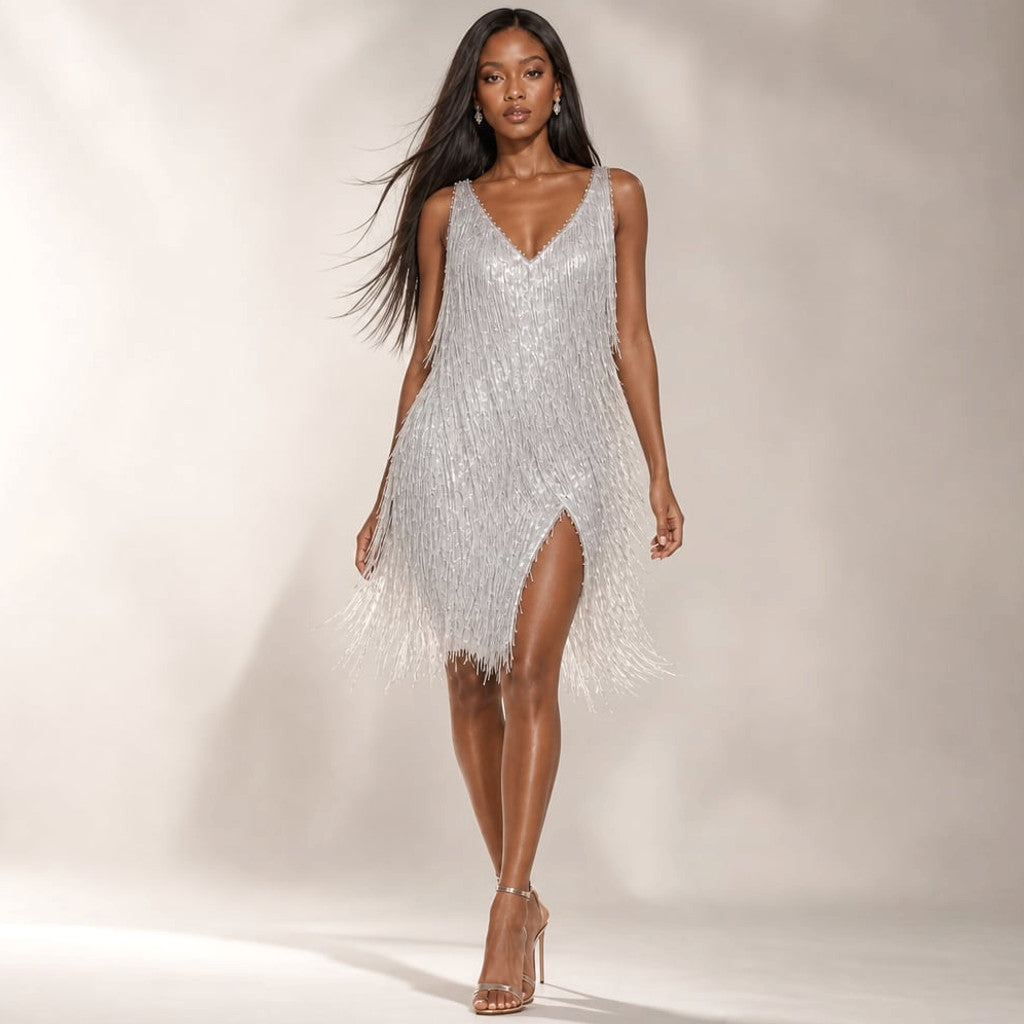 Model wearing silver all-over sequin mini dress with stacked fringe tiers at skirt and deep V-neckline