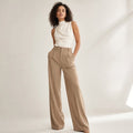 Model wearing Teva high-waist wide-leg tailored trouser in camel summer-weight fabric, front view