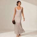 Model wearing neutral check sleeveless maxi dress with sheer overlay layer over fitted mini lining, photographed at full length